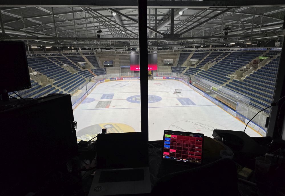 Blick aus der Technik-Kabine der St. Jakob Arena auf das leere Eisfeld, im Vordergrund Laptop und Bedienpult